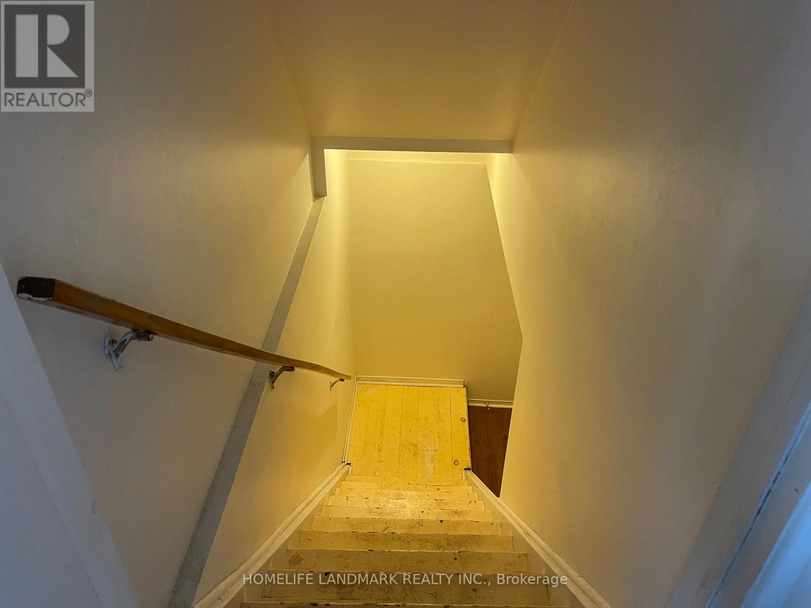 A staircase leading to a landing with a light on the side.