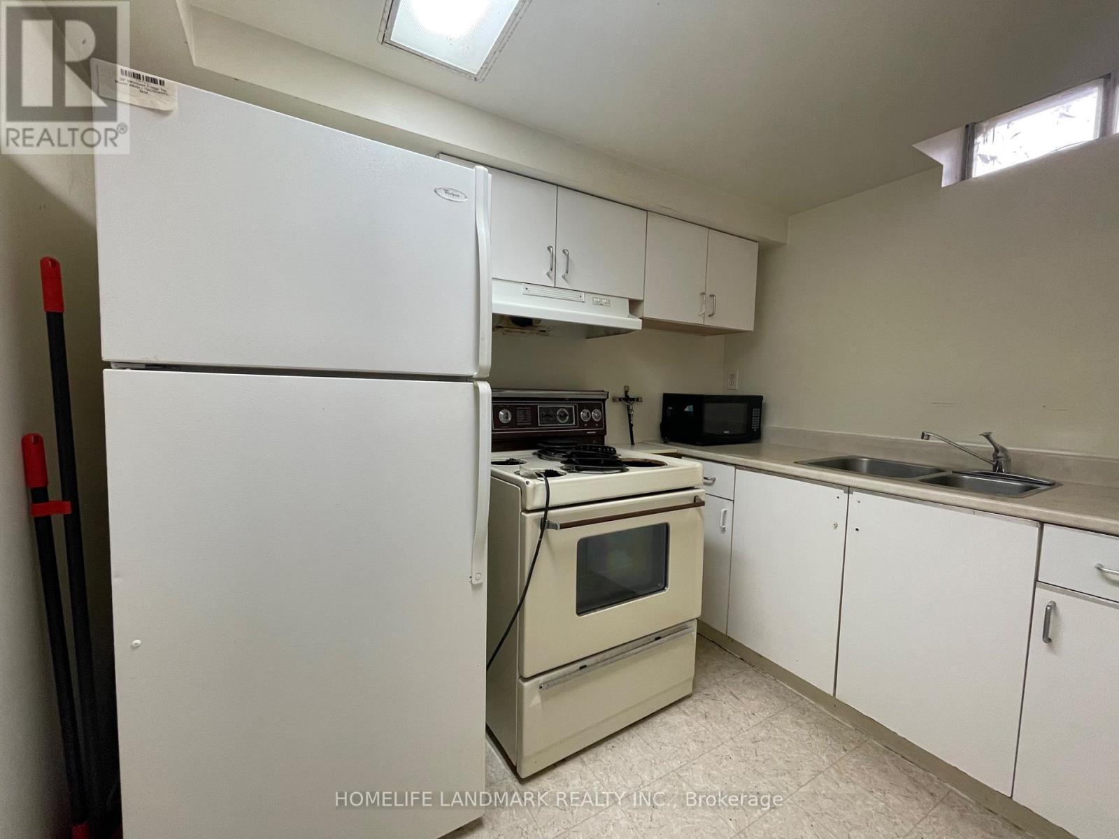 A kitchen with a white refrigerator, oven, and microwave.