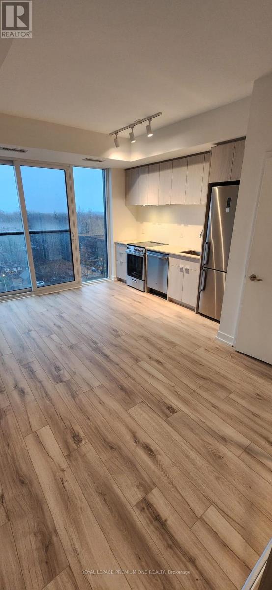 A kitchen with white cabinets and a refrigerator.