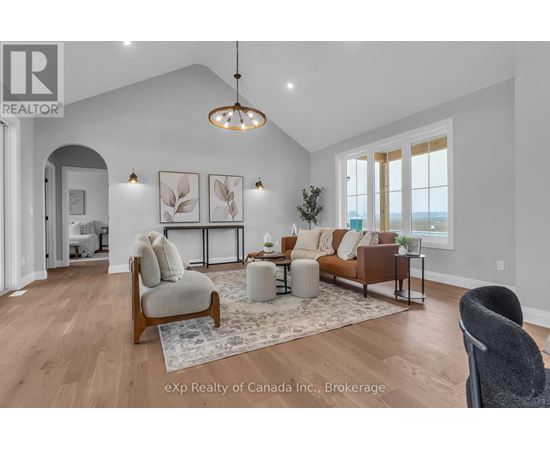 A living room with a grey sofa, a white armchair, and a wooden floor.