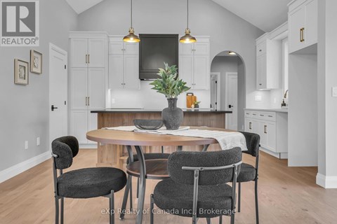 A kitchen with a table and chairs in the foreground.