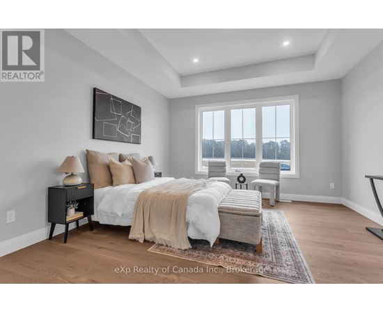 A bedroom with a large bed and a window overlooking trees.