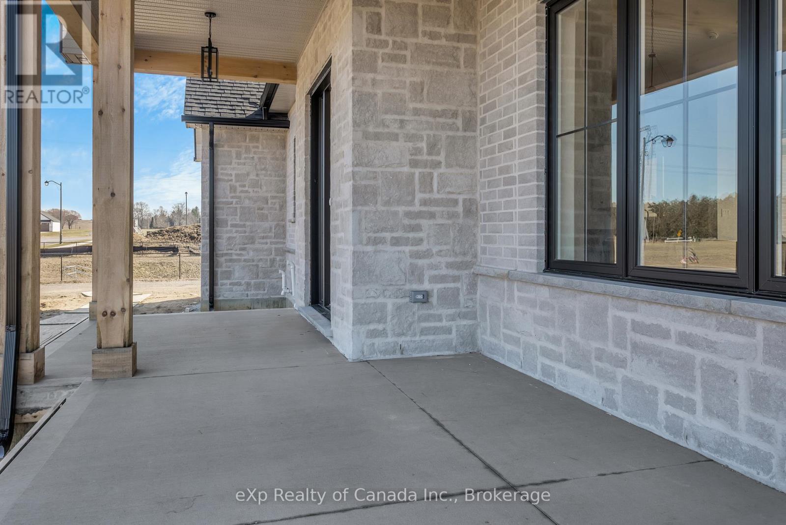 The entrance of a building with a stone wall and glass windows.
