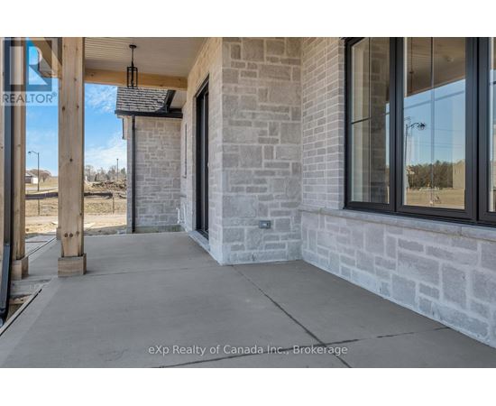 The entrance of a building with a stone wall and glass windows.