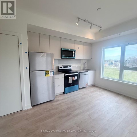 A kitchen area with a refrigerator, microwave, and a dishwasher.