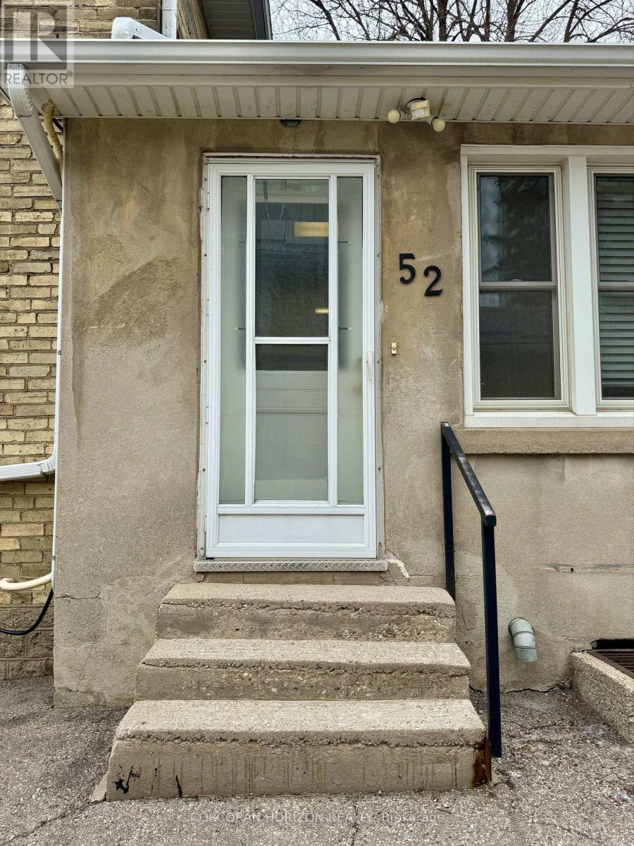 A house with a white door and window with the number 52 on it.