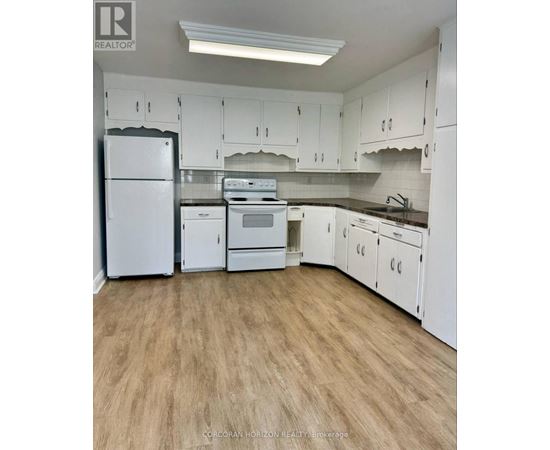 A kitchen with white appliances and cabinets.