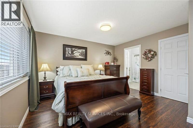 A bedroom with a bed, nightstand, and a brown leather bench.