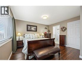 A bedroom with a bed, nightstand, and a brown leather bench.