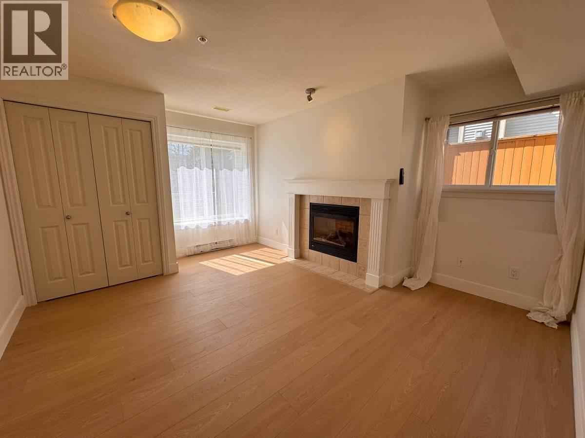 A living room with a fireplace and a door on the left.