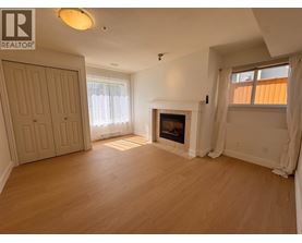 A living room with a fireplace and a door on the left.