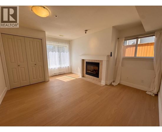 A living room with a fireplace and a door on the left.