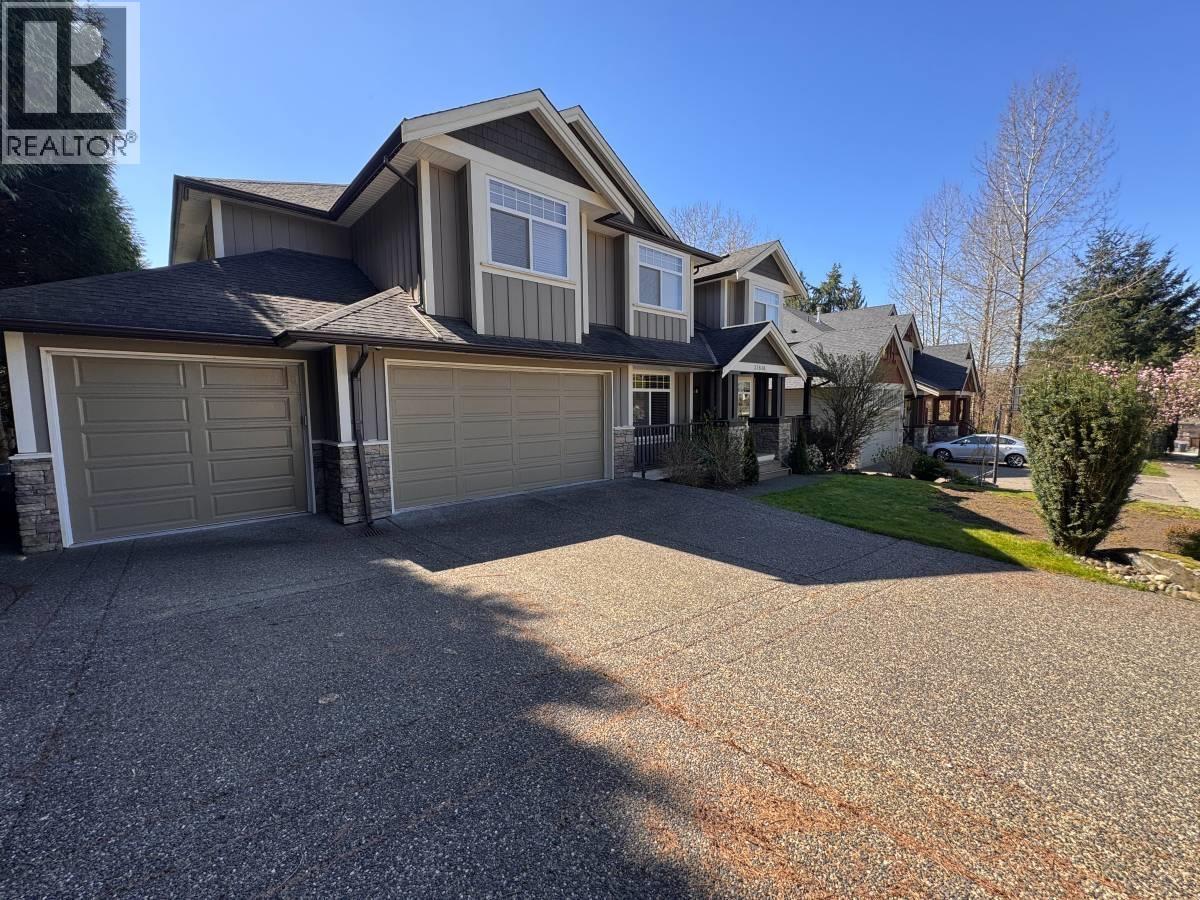 A large house with a grey garage door is for sale.