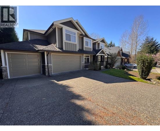 A large house with a grey garage door is for sale.