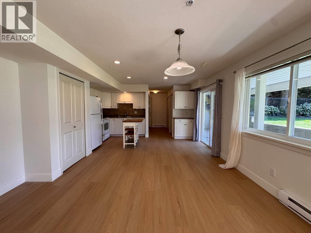 A spacious room with wooden flooring and a white ceiling.