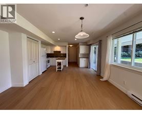 A spacious room with wooden flooring and a white ceiling.