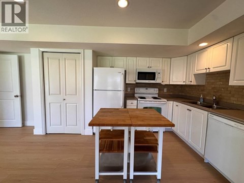 A kitchen with a table and chairs in the middle of the room.