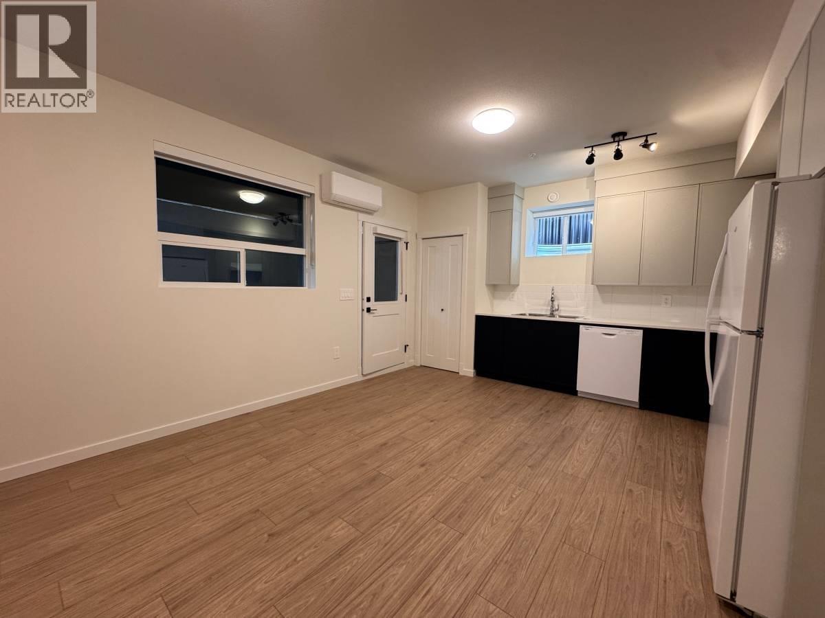 A well-lit, empty room with wooden flooring and white walls.