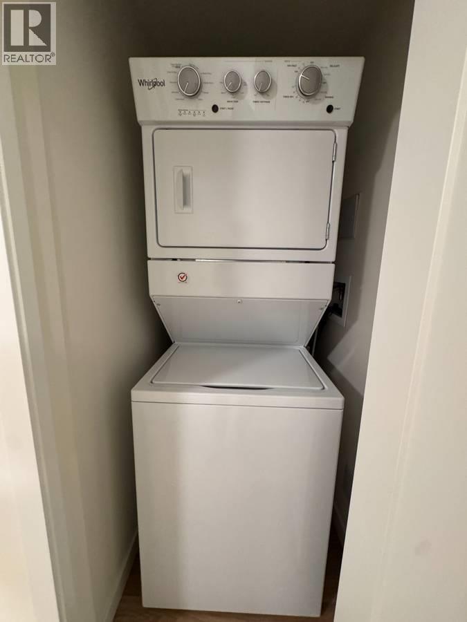 A white Whirlpool dishwasher and dryer stacked on top of each other.