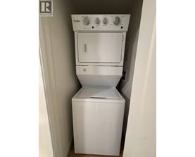 A white Whirlpool dishwasher and dryer stacked on top of each other.
