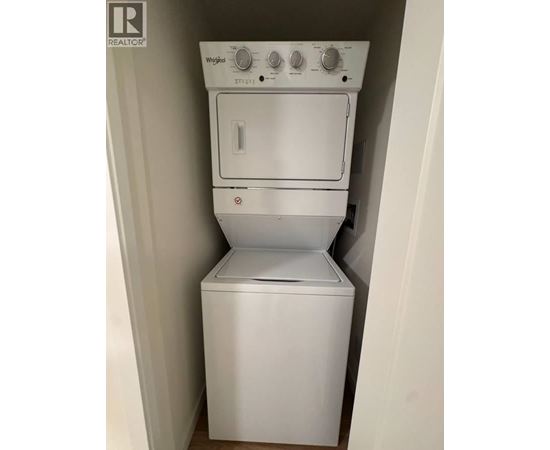 A white Whirlpool dishwasher and dryer stacked on top of each other.
