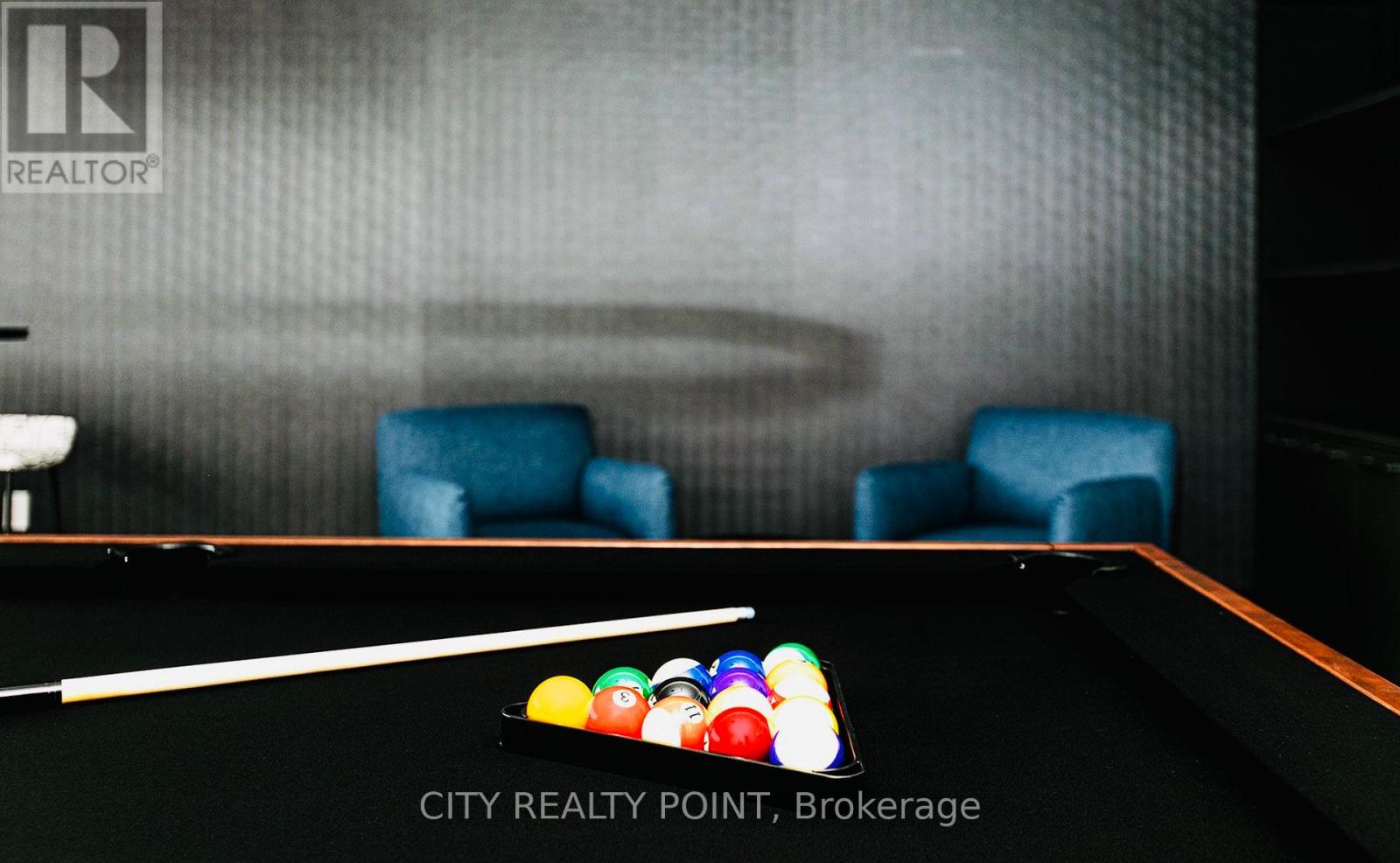 A pool table with a white cue stick and a ball rack on it.
