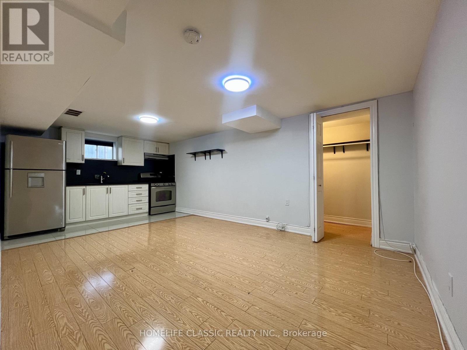 A well-lit, empty room with wooden flooring and white walls.