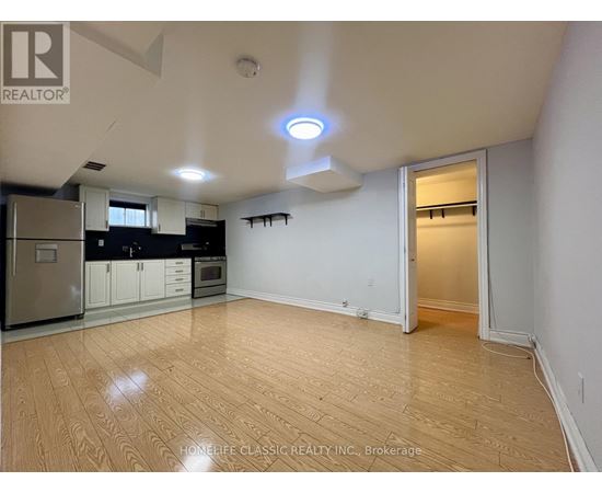 A well-lit, empty room with wooden flooring and white walls.
