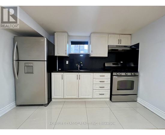 A kitchen with white cabinets and a stainless steel refrigerator.