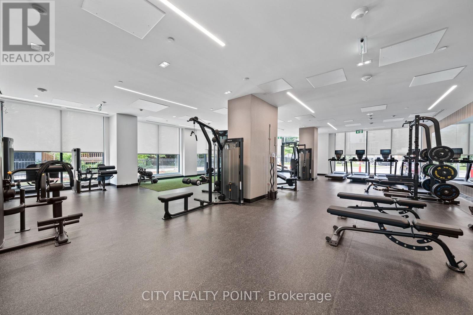 A gym with a variety of equipment including treadmills, weights, and exercise machines.