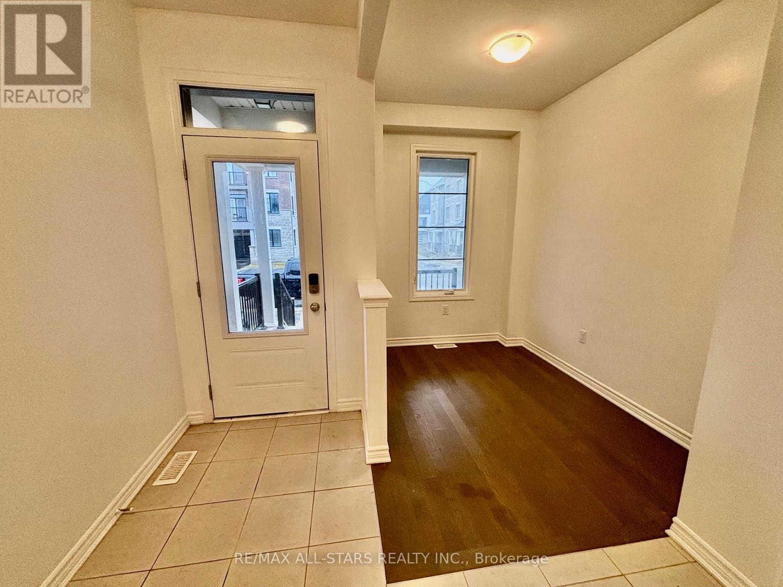 A room with a white door and a window with a view of a building outside.