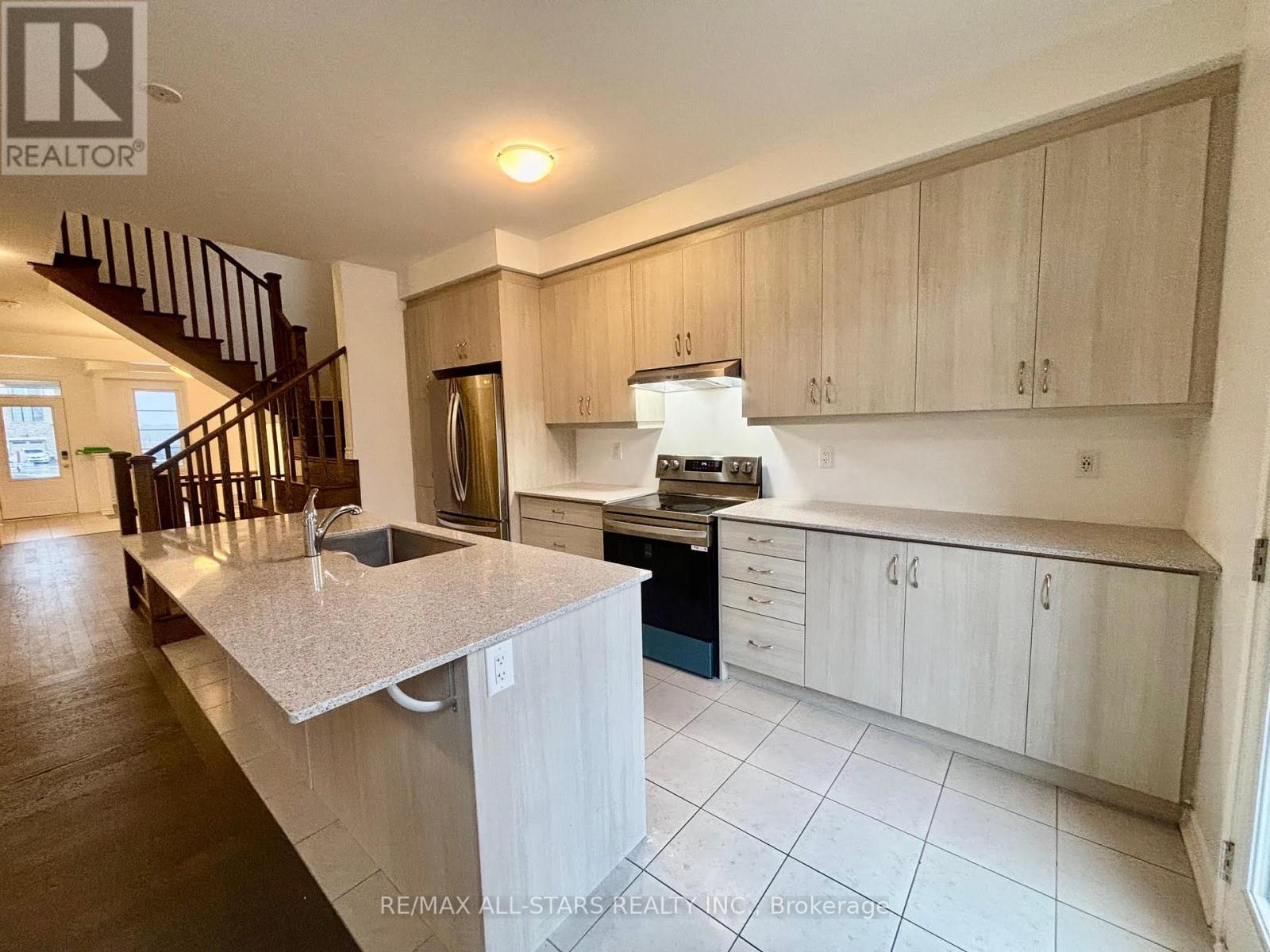A kitchen with a staircase leading to the upper floor.