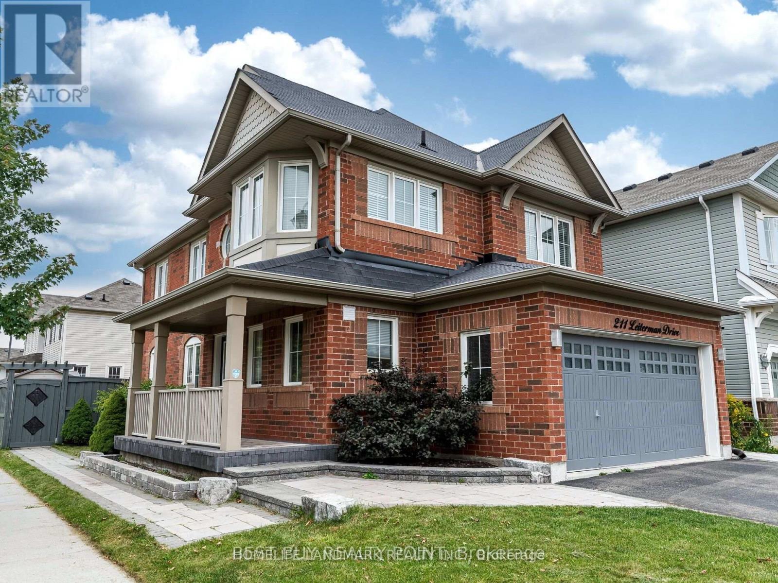 A large brick house with a grey garage door.