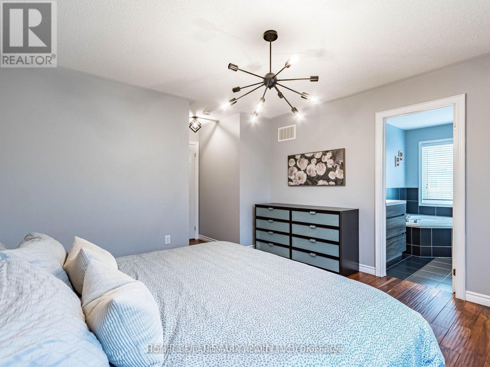 A bedroom with a large bed and a chandelier.