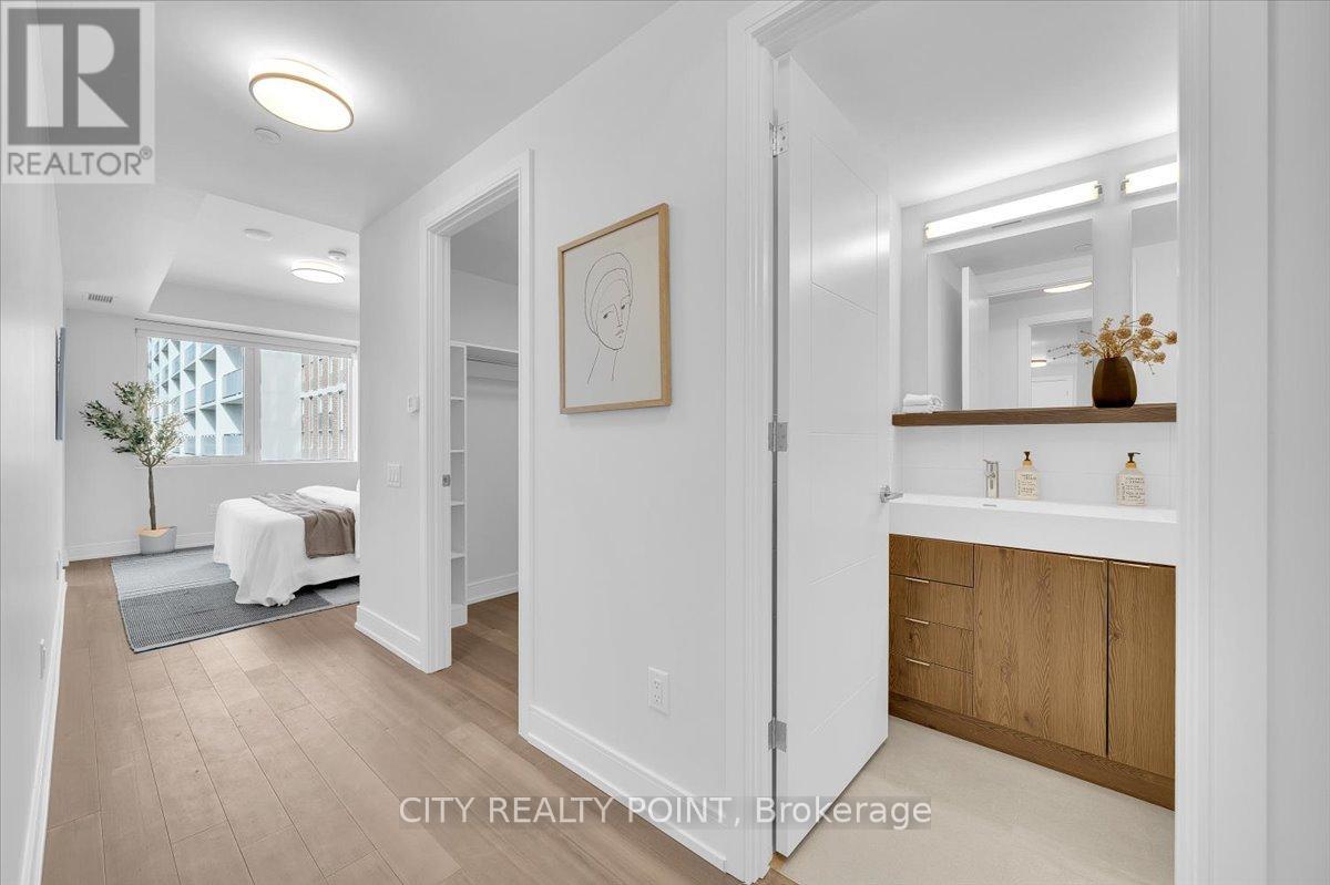 A well-lit, spacious room with a bed, a mirror, and a framed picture on the wall.