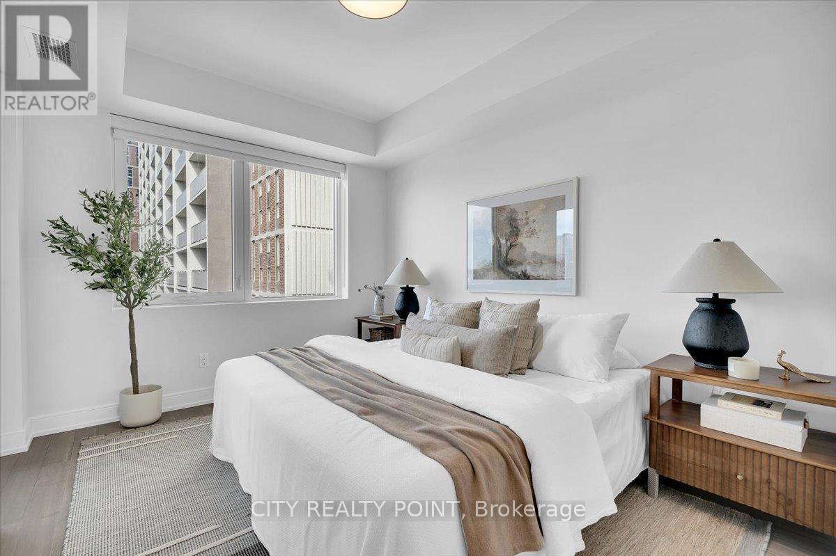 A bedroom with a large bed and a potted plant.