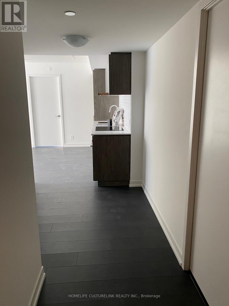 A hallway with a sink and a door in the background.