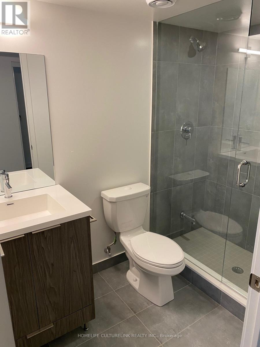 A white toilet sits next to a walk-in shower in a bathroom.