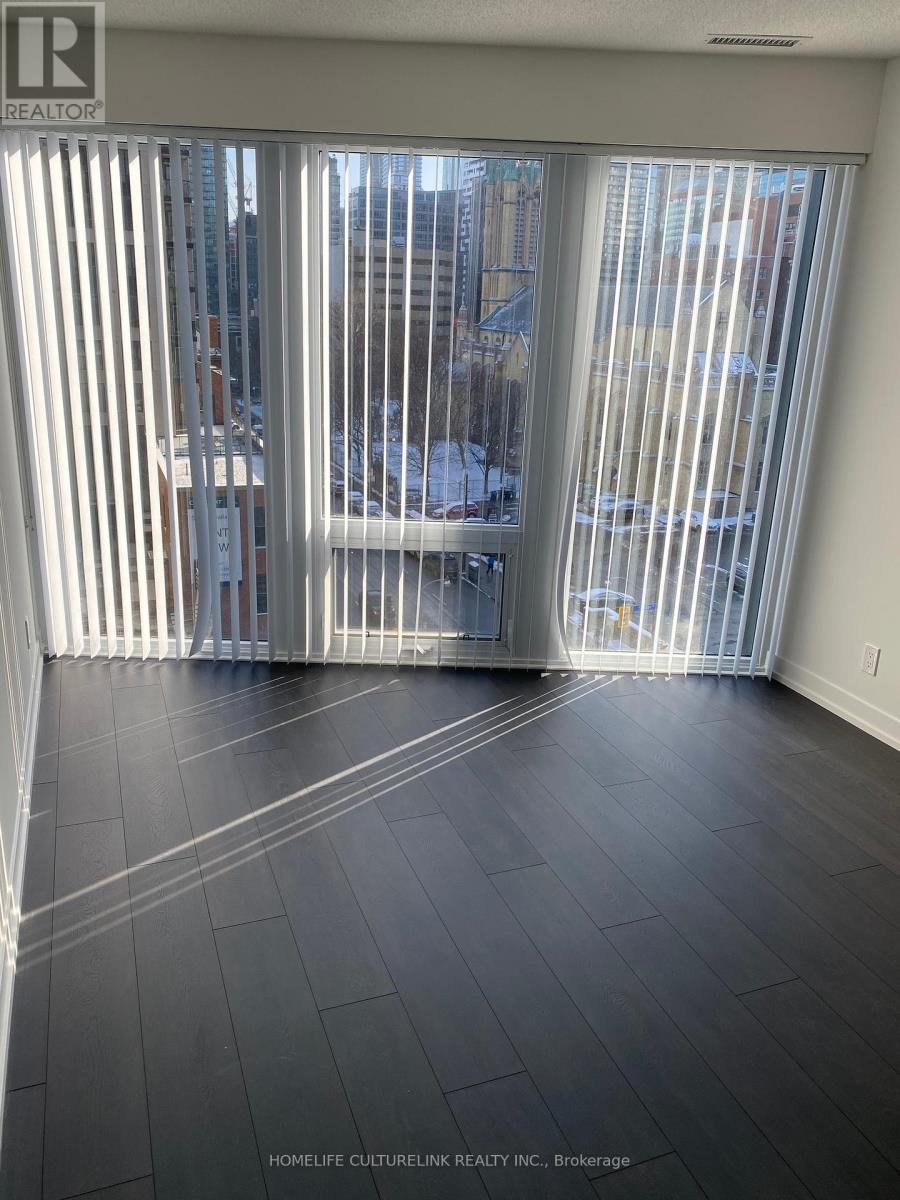 A room with a sliding glass door leading to a balcony.