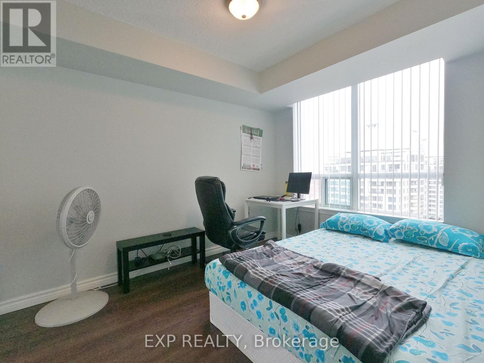 A bedroom with a bed, desk, and chair.