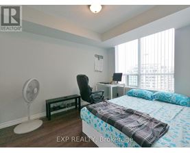 A bedroom with a bed, desk, and chair.