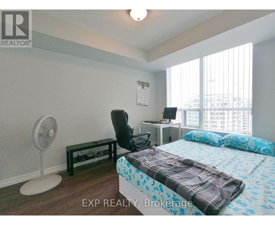 A bedroom with a bed, desk, and chair.