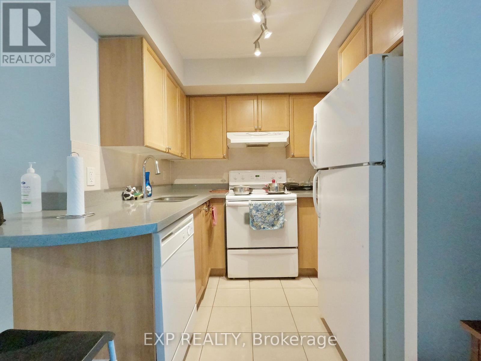 A kitchen with wooden cabinets and a white refrigerator.