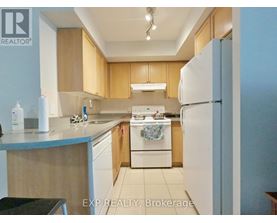 A kitchen with wooden cabinets and a white refrigerator.