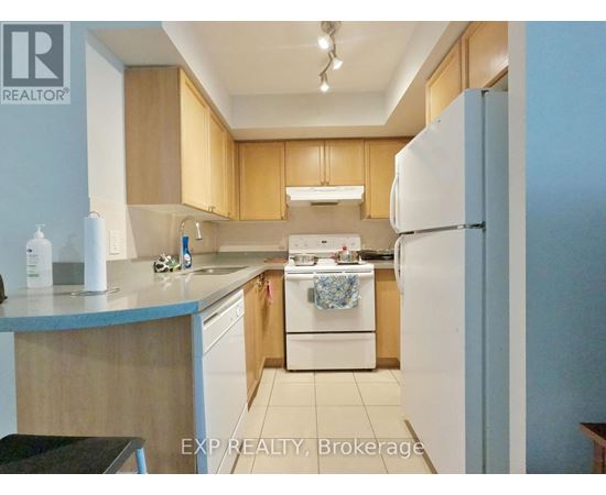 A kitchen with wooden cabinets and a white refrigerator.