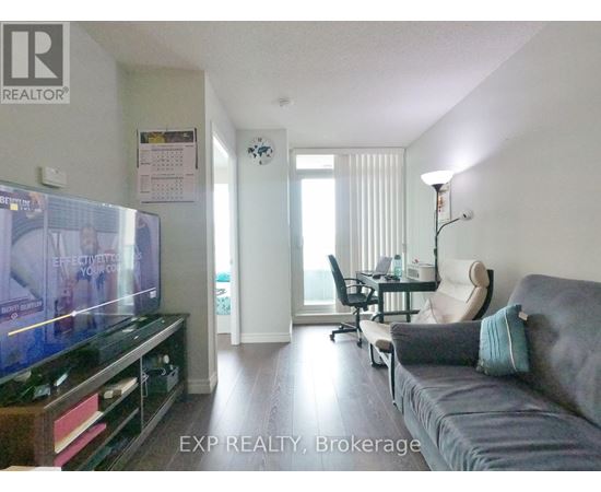 A living room with a grey couch and a flat screen TV.