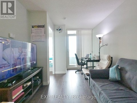 A living room with a grey couch and a flat screen TV.