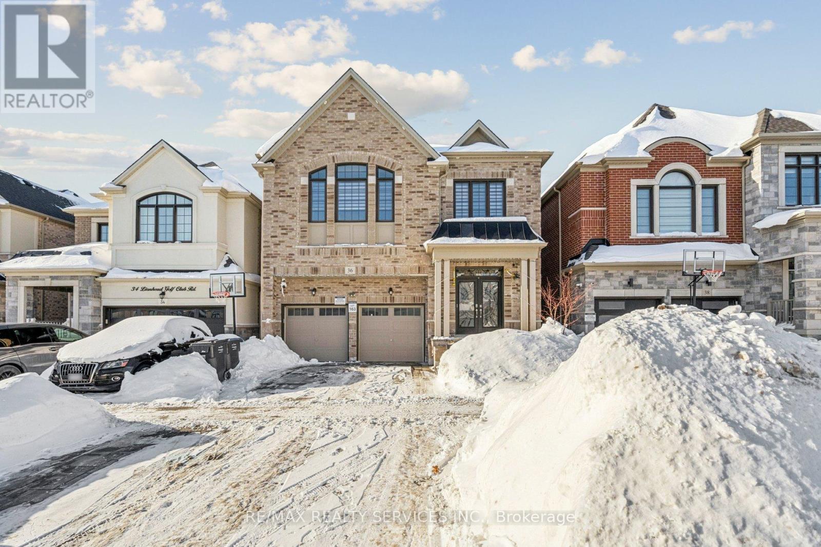 A house with a snow-covered driveway in front of it.