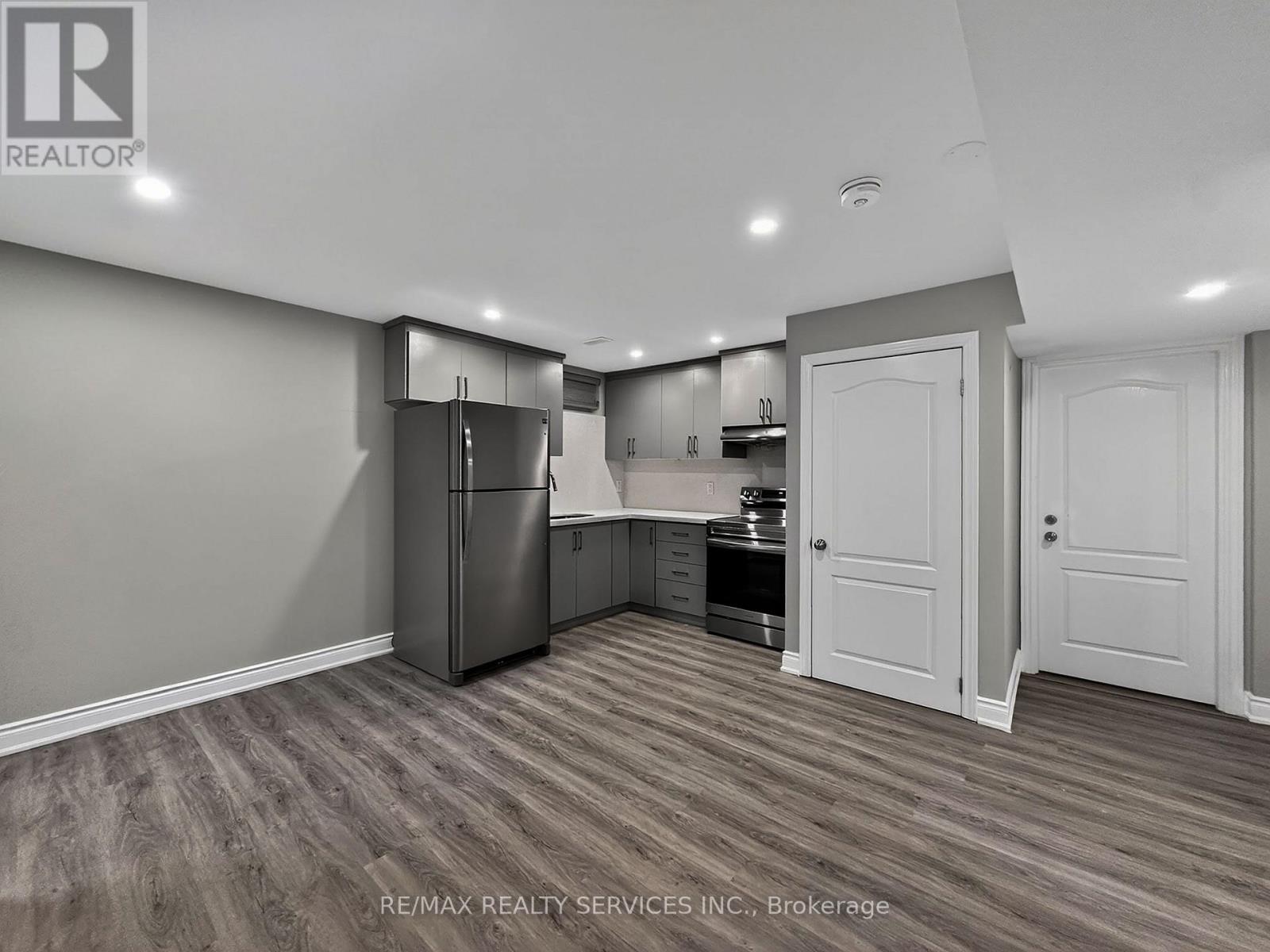 A kitchen area with a refrigerator, cabinets, and a countertop.