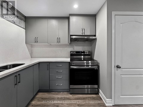 A kitchen with grey cabinets and a white door.